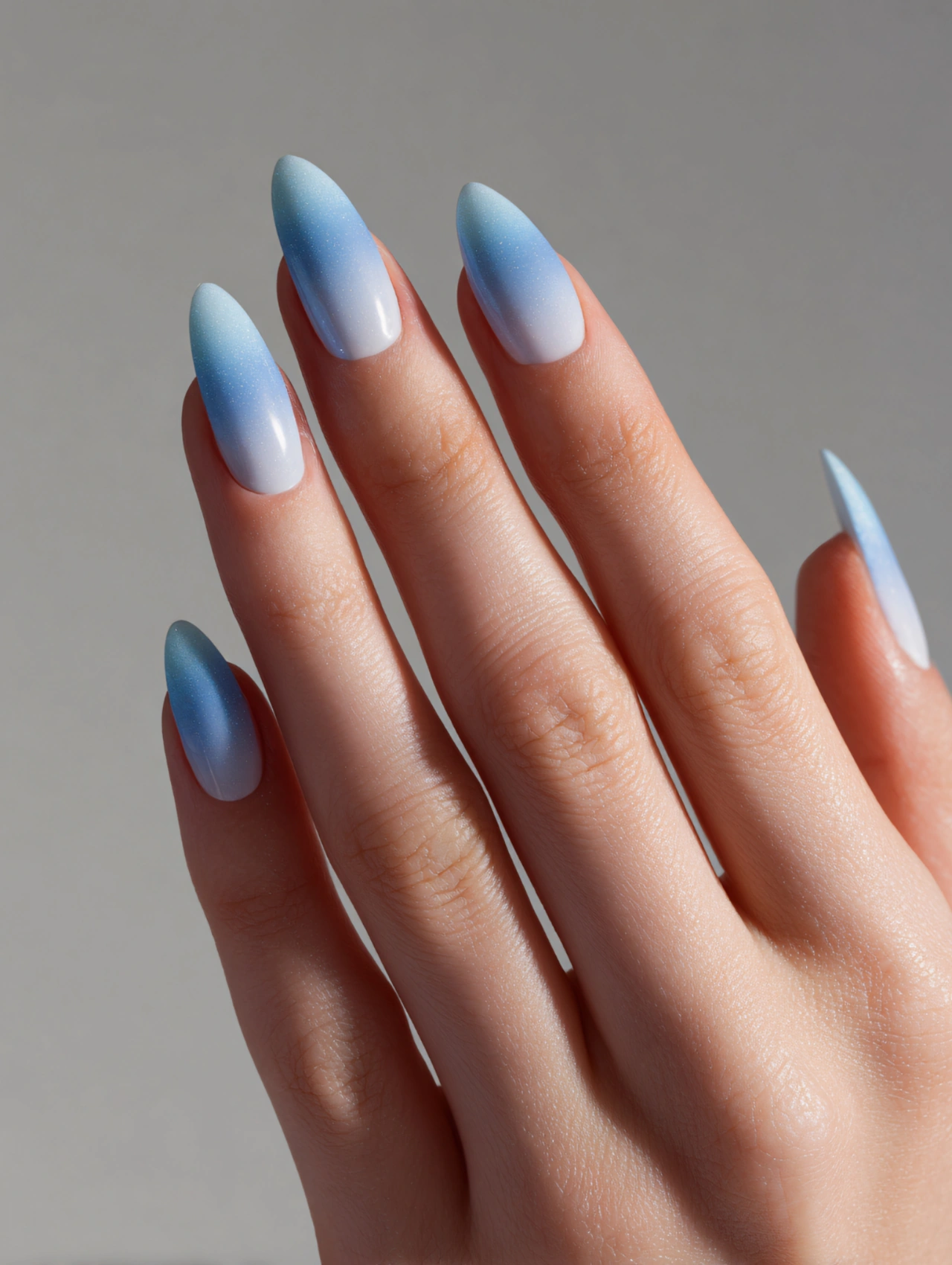 Icy Blue Ombre Almond January Nails with gradient blue tones on almond-shaped nails.