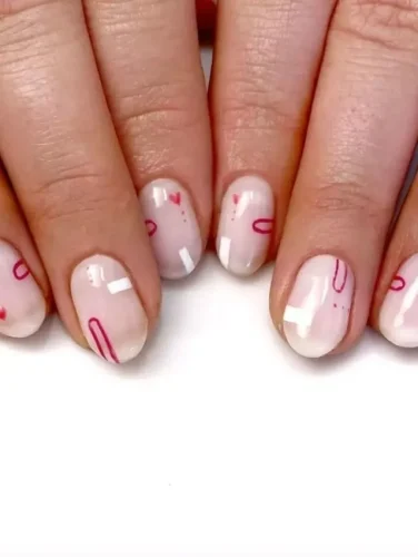 Este diseño de uñas sobrio pero elegante presenta una base translúcida y lechosa con sutiles toques de rubor, exudando un aspecto suave y natural. Delicados corazones abstractos en tono rosa adornan cada uña, ofreciendo un toque minimalista pero festivo para San Valentín. La simplicidad del diseño y el suave toque de color lo hacen una opción versátil para aquellos que prefieren un estilo refinado y gracioso para sus celebraciones de San Valentín.