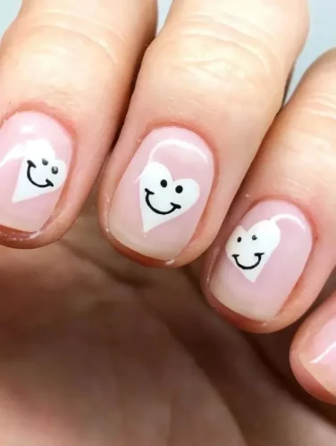 Este encantador diseño de uñas presenta una base rosa translúcida que irradia calidez y ternura, perfecta para mostrar afecto. Cada uña está adornada con un corazón sonriente, pintado en un blanco nítido que resalta contra el fondo suave, añadiendo un toque juguetón y alegre. Ideal para aquellos que aman difundir felicidad y amor con un toque de capricho, este diseño es un guiño delicioso al espíritu del Día de San Valentín.