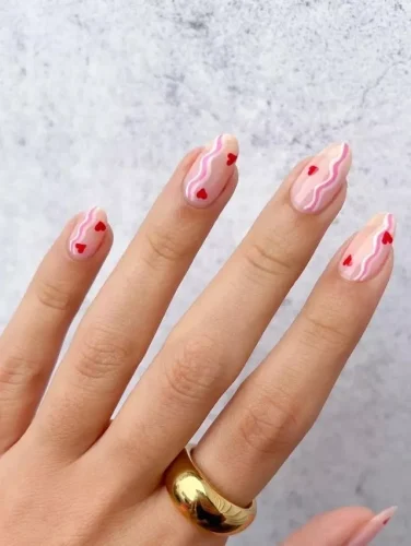 Este elegante diseño de uñas presenta una suave base rosa lechosa con patrones de mármol rojo vibrante que imitan con gracia el flujo de cintas de seda románticas. Pequeños corazones rojos se colocan delicadamente dentro de los remolinos, añadiendo un toque encantador de San Valentín. Perfecto para quienes aprecian el arte y la sutileza en su estilo, este diseño ofrece un look sofisticado y romántico, ideal para cualquier ocasión llena de amor.