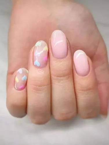 Este delicado diseño de uñas presenta una suave base rosa con un acabado brillante y natural, irradiando una elegancia sin esfuerzo. Las uñas de acento muestran globos flotantes en forma de corazón en tonos pastel de azul bebé, amarillo limón, melocotón y lavanda, conectados con finas líneas blancas para un toque caprichoso. Perfecto para quienes aman un look de San Valentín sutil pero juguetón, este diseño de ensueño evoca un romance ligero con una sensación fresca y etérea.