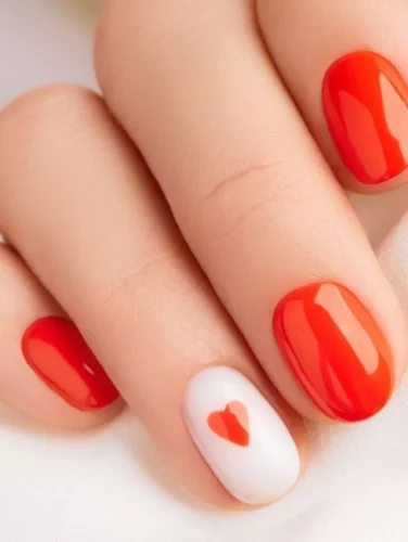 Este lujoso diseño de uñas se llama "romance de cristal," que personifica el encanto del Día de San Valentín con su estética vibrante y amorosa. Las uñas presentan una base brillante de rojo manzana y rosa pálido, adornadas con intrincados patrones de corazones y espirales acentuados por destellantes piedras.