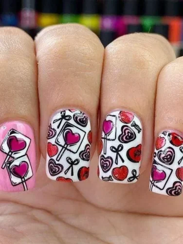 Este divertido y artístico diseño de uñas está decorado con piruletas en forma de corazón, cartas de amor y pequeños lazos dibujados a mano, creando una encantadora estética de garabatos. La combinación de una uña de acento en rosa brillante con fondos blancos nítidos realza el contraste, haciendo que los contornos negros resalten. Perfecto para quienes adoran un diseño creativo, juguetón y lleno de fantasía para San Valentín, este estilo parece una historia de amor dibujada directamente desde el corazón.