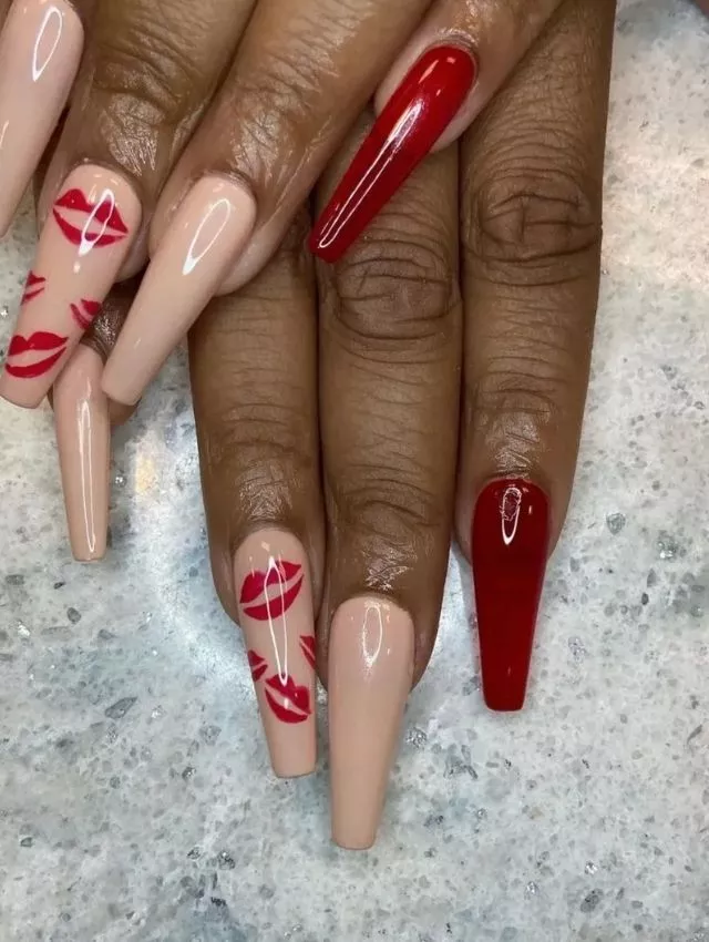 Este audaz y seductor diseño de uñas presenta una irresistible combinación de tonos nude brillantes y rojo intenso, creando un contraste impactante. Las uñas de acento destacan con delicadas huellas de labios rojos, agregando un toque juguetón y coqueto que captura la esencia del romance. Perfecto para quienes aman una manicura glamurosa y seductora para San Valentín, este diseño en forma de ataúd largo irradia confianza, pasión y un encanto irresistible.