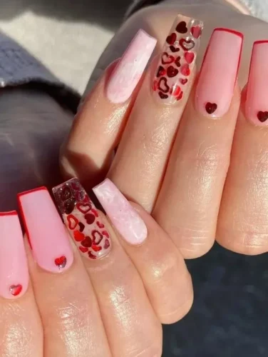 ¡Estas largas uñas en forma de ataúd son la declaración definitiva para el Día de San Valentín! Una mezcla de diseños ombré rosa y translúcido, audaces puntas francesas rojas y uñas cristalinas adornadas con calcomanías de corazones rojos crean una estética romántica pero moderna. Terminadas con pequeños detalles de corazones para un toque extra de encanto, este look es perfecto para quienes aman la mezcla de elegancia y diversión.