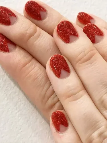 Estas deslumbrantes uñas para el Día de San Valentín presentan un diseño único de puntas en forma de corazón con esmalte rojo brillante, creando un contraste impresionante con la base nude natural. El efecto de corte agudo le da un giro moderno y juguetón a un look romántico clásico. Perfecto para quienes aman el arte de uñas sutil pero llamativo que irradia amor y elegancia.