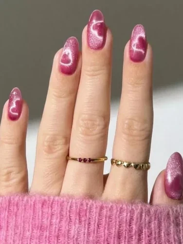 Este fascinante diseño de uñas para San Valentín presenta un profundo efecto cat-eye rosa con formas de corazones brillantes que centellean bajo la luz. El esmalte magnético crea una ilusión celestial y soñadora, haciéndolo perfecto para una vibra romántica y mágica. ¡Ideal para quienes aman diseños elegantes pero juguetones que brillan con cada movimiento!