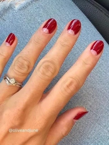 Una manicura roja profunda atemporal con un giro moderno: este diseño presenta un detalle en espacio negativo en forma de luna en la base de cada uña, creando un look chic y sofisticado sin esfuerzo. El esmalte rojo rubí brillante añade un toque audaz pero elegante, haciéndolo perfecto para cualquier ocasión. Ya sea que busques una estética inspirada en lo vintage o una vibra minimalista contemporánea, ¡esta manicura es una declaración impecable de estilo!