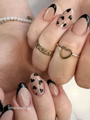 ¡Una impresionante mezcla de elegancia y audacia! Este diseño de uñas presenta una base nude con audaces puntas francesas negras y corazones negros dispersos para un look sofisticado de San Valentín. Perfecto para quienes aman una manicura moderna y elegante con un toque de romance.