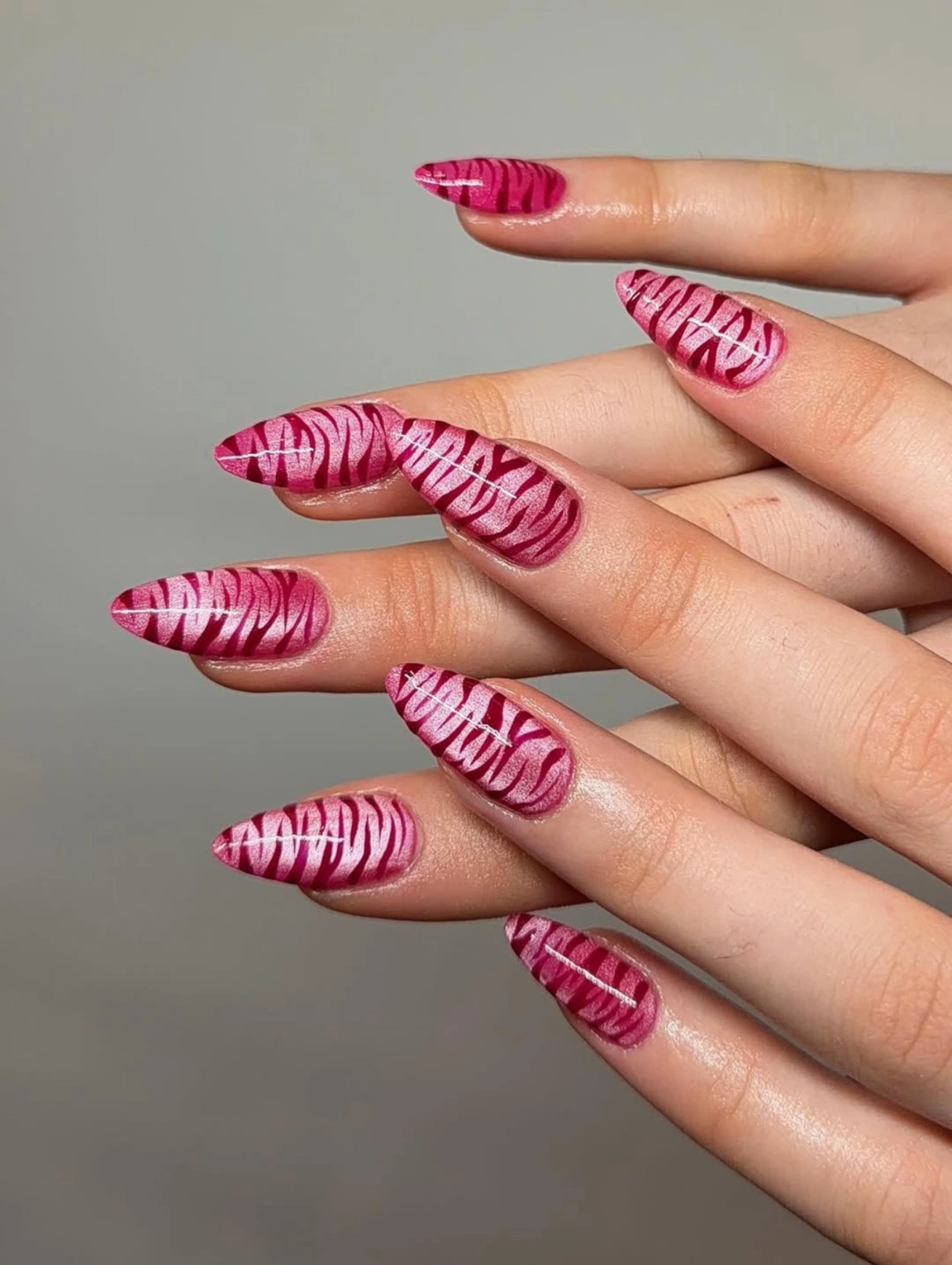 Berry Zebra Print Valentineโs Nails Almond with almond-shaped nails in deep pink tones and zebra-inspired patterns.