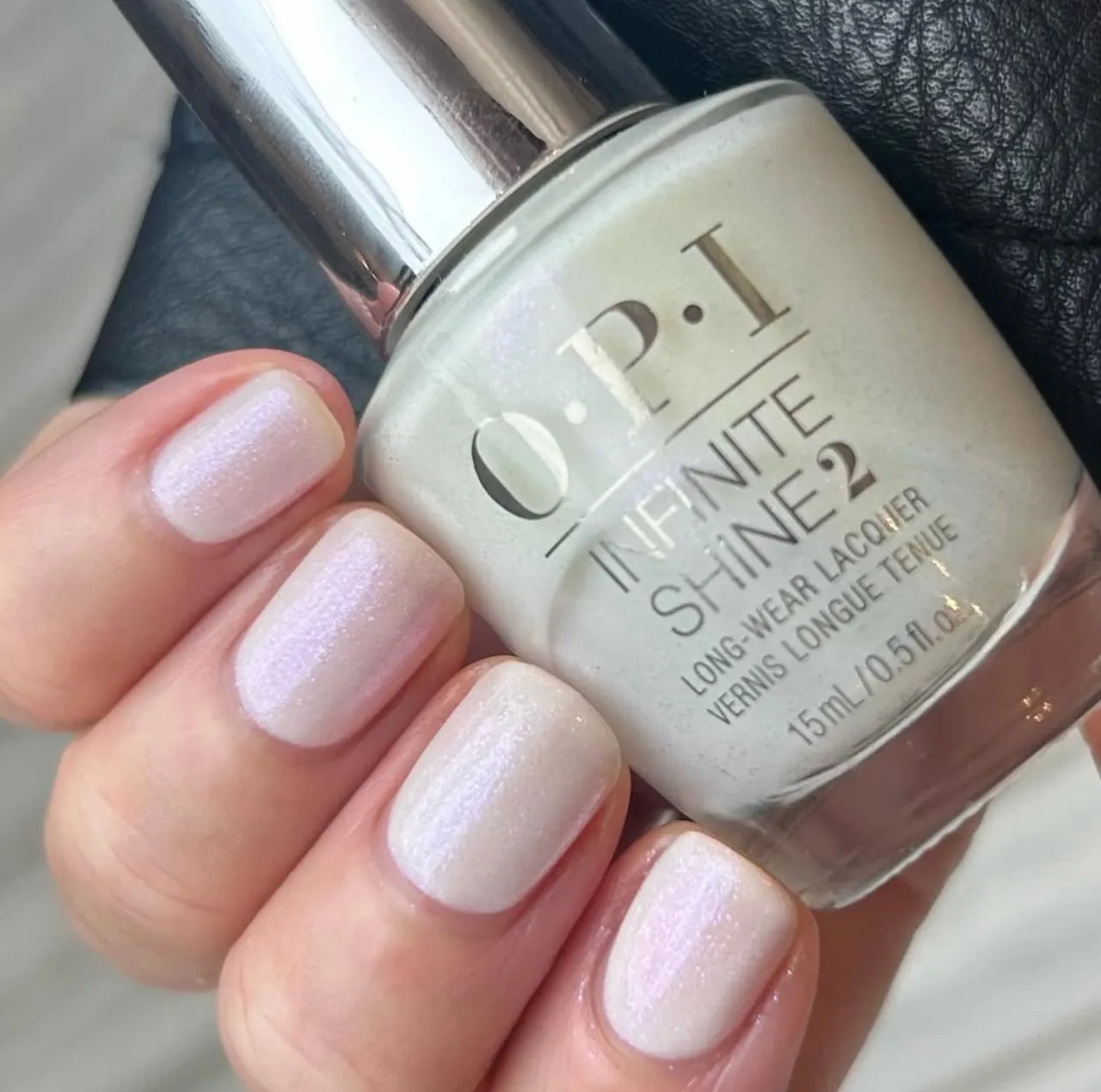 Diseño de uñas con esmalte OPI Infinite Shine en Chill 'Em With Kindness, color blanco perlado con shimmer, ideal para los colores de uñas de invierno en tendencia.