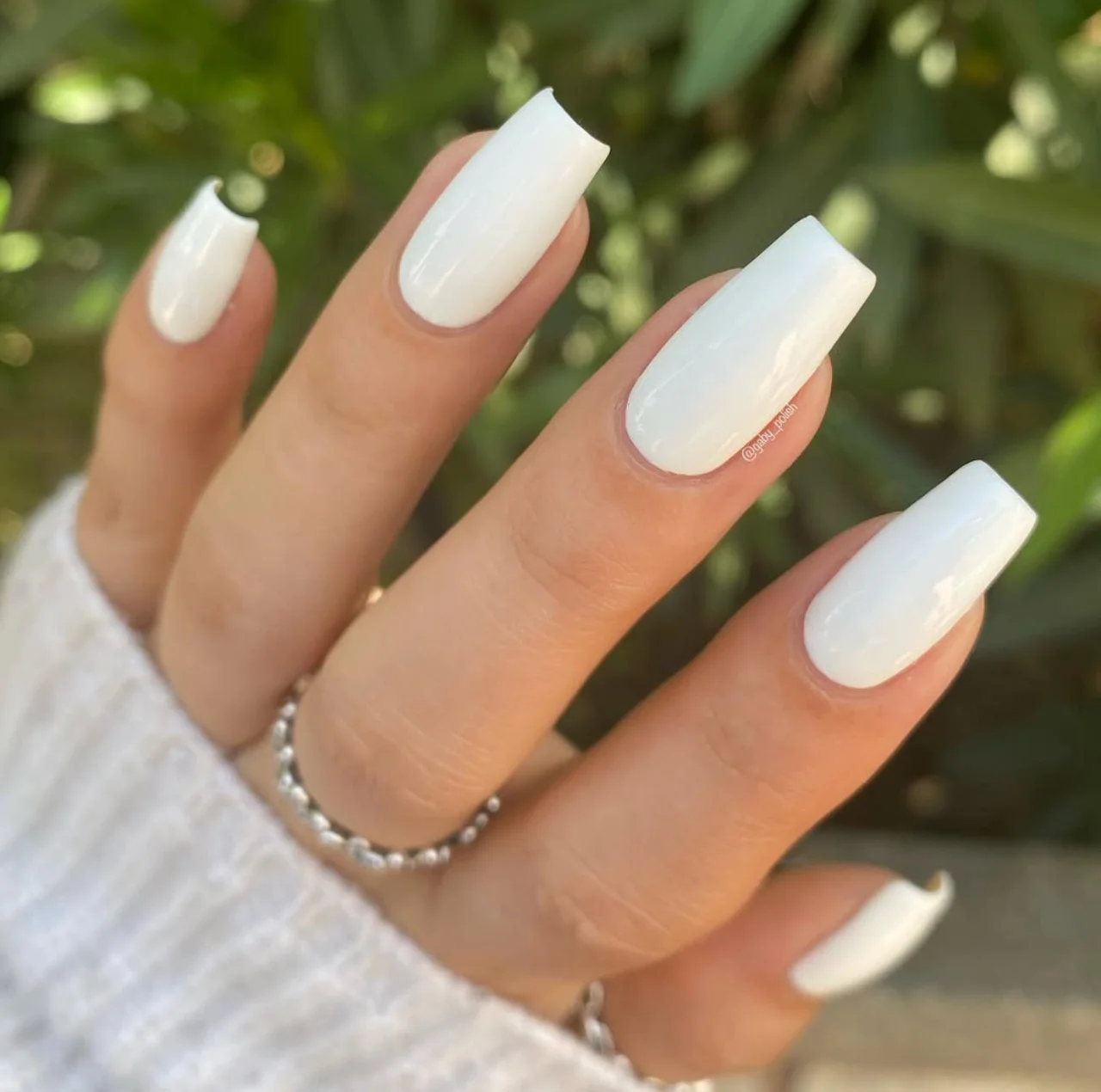 Uñas con esmalte Chanel Le Vernis Longwear Nail Colour en Insomniaque, un blanco perlado ideal para los colores de uñas de invierno en tendencia.