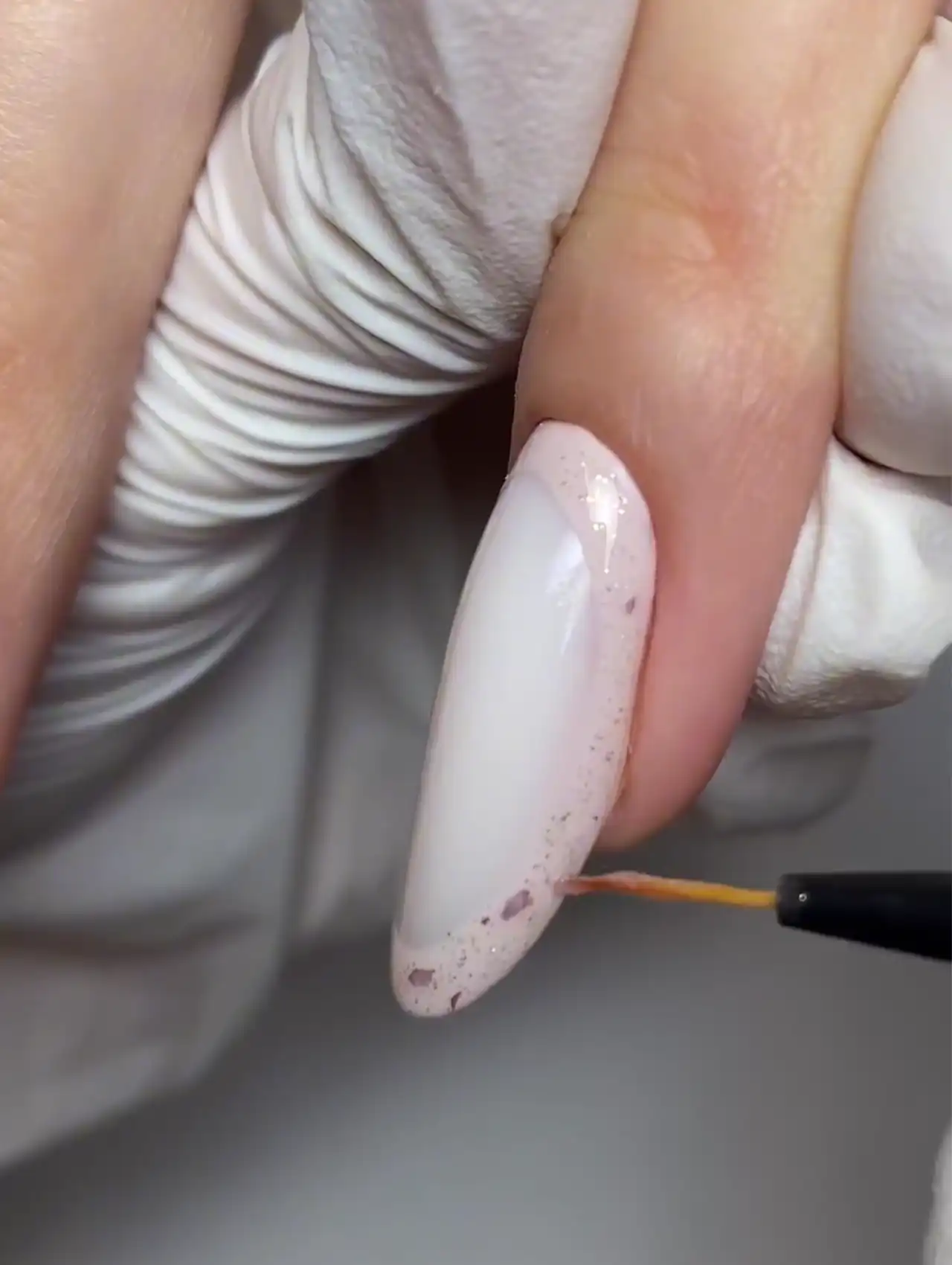Uña decorada con efecto glitter suave en tono rosado – cómo hacer arte en uñas de invierno.