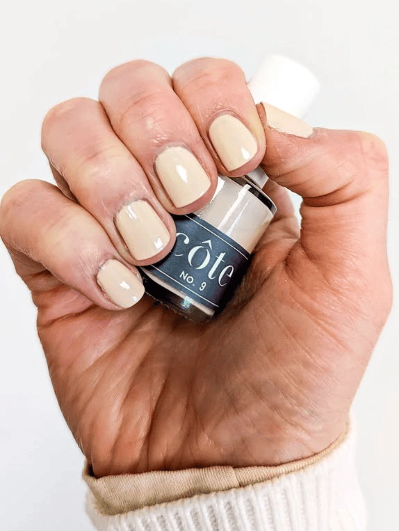 Manicura con esmalte Côte en tono beige claro, mostrando uno de los colores de uñas de invierno en tendencia más naturales.