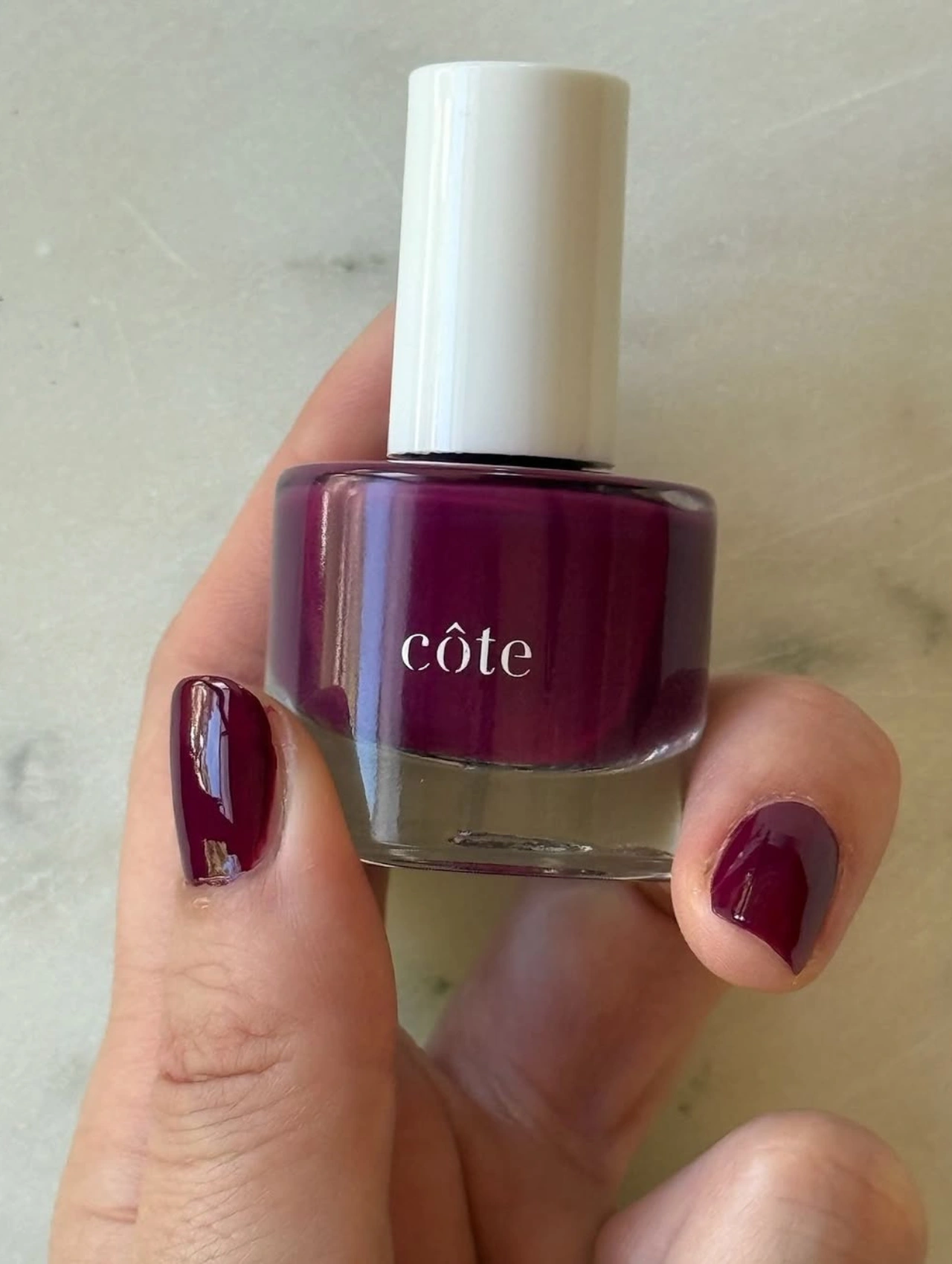 Uñas en tono borgoña con esmalte Côte Sangria, inspiradas en los colores de uñas de invierno en tendencia.