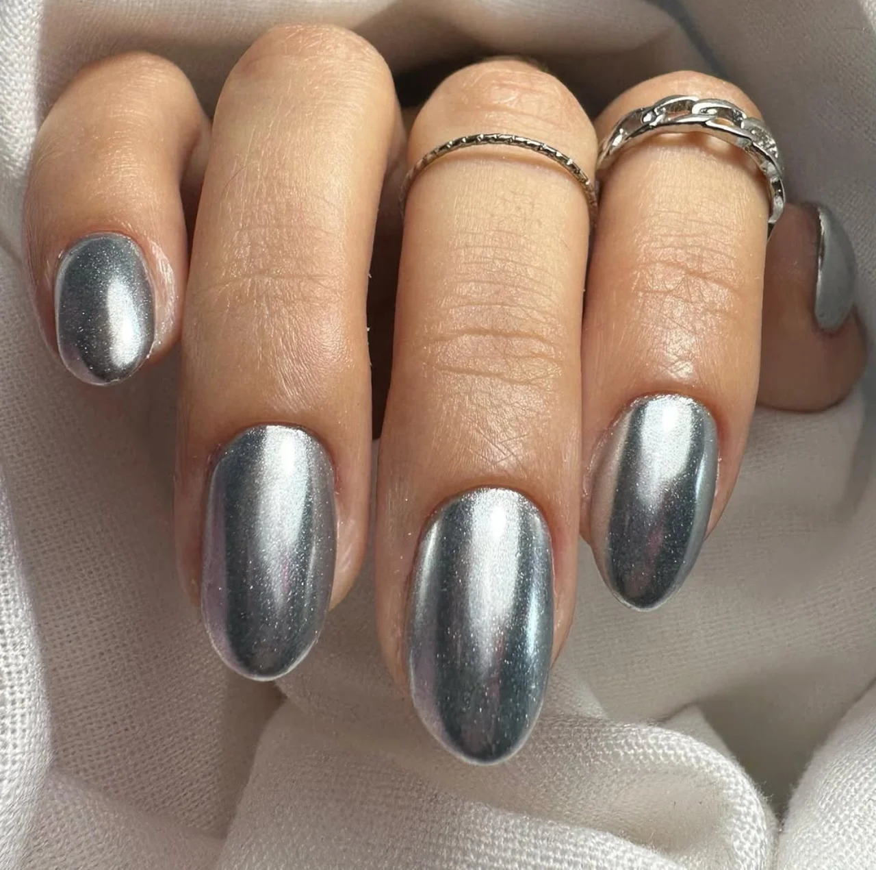 Uñas estilo cromo plateado futurista perfectas para Nochevieja.
