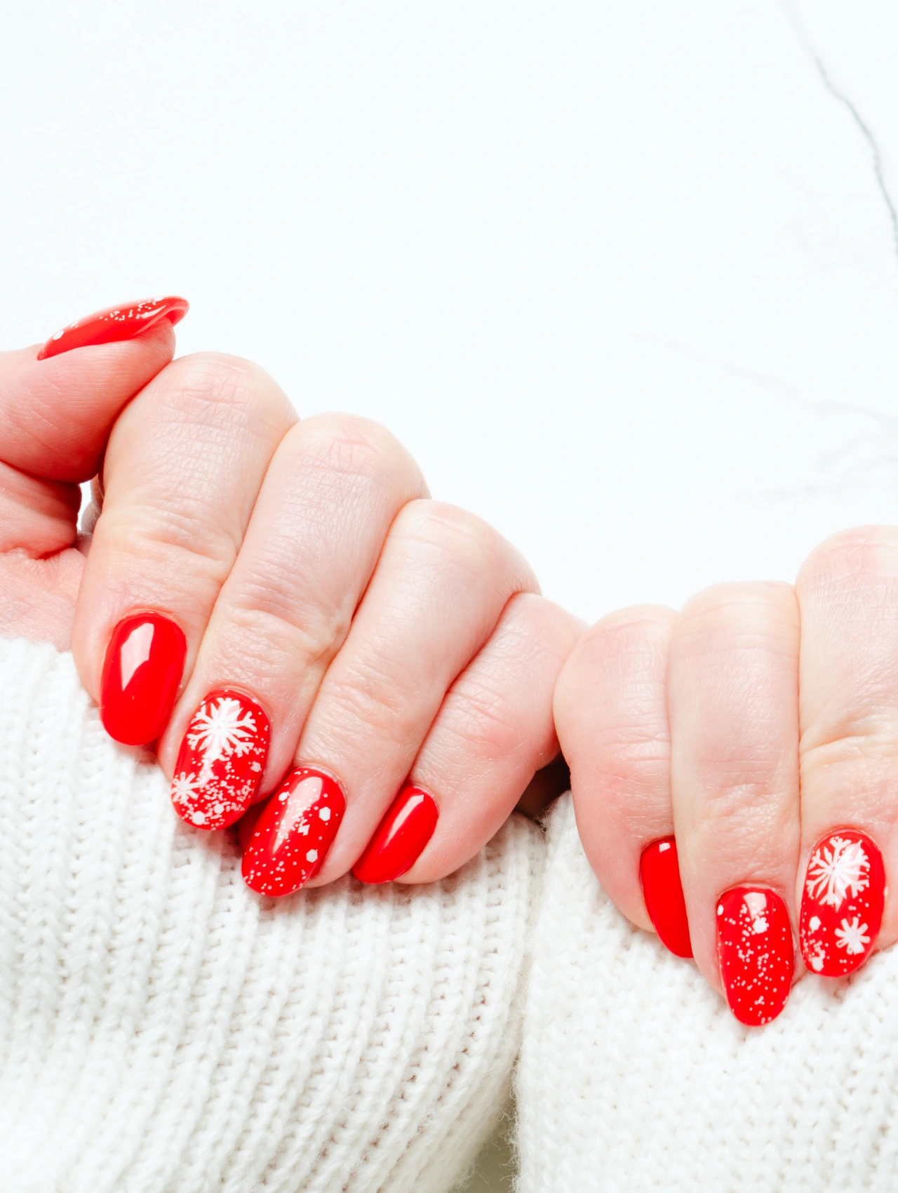 Bright red winter manicure with snowflake nail art, perfect for festive December Nails