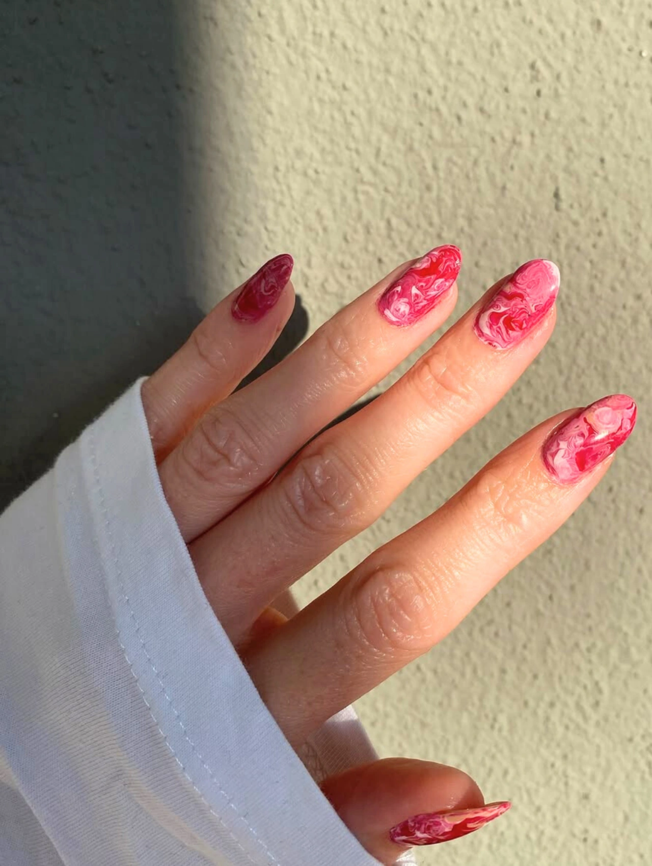 Easy DIY Valentine’s Day Nail Art featuring pink marble swirl designs for a bold and artistic manicure