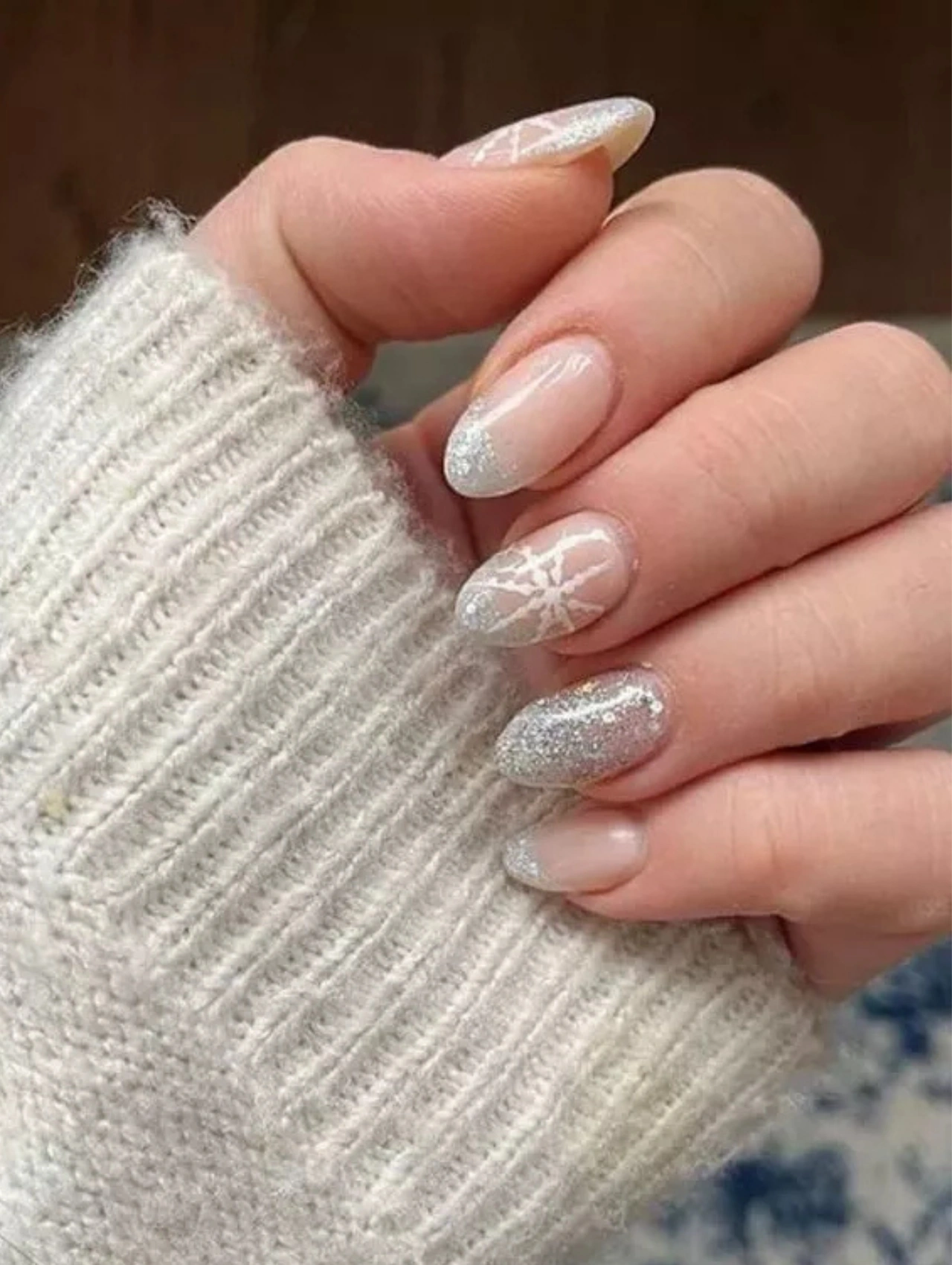 Silver glitter manicure with frosted snowflake accents, a classic holiday look for December Nails