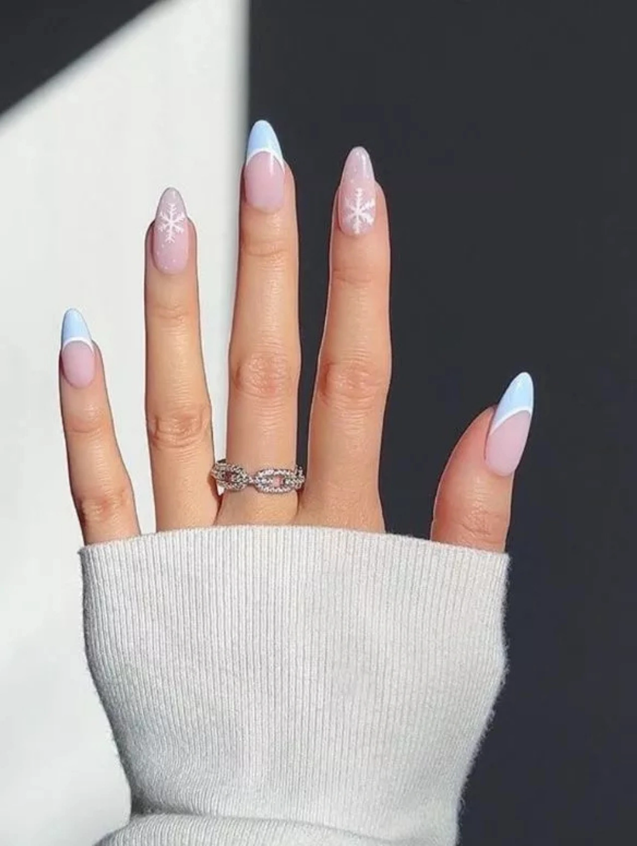 Pastel blue French tip nails with small snowflake accents, a fresh and playful take on December Nails