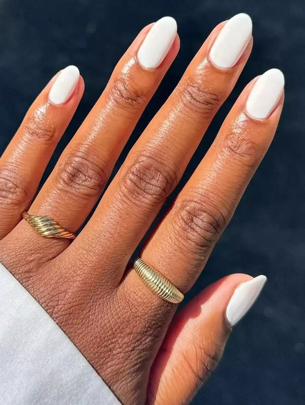 Classic solid white nail polish on short oval nails.