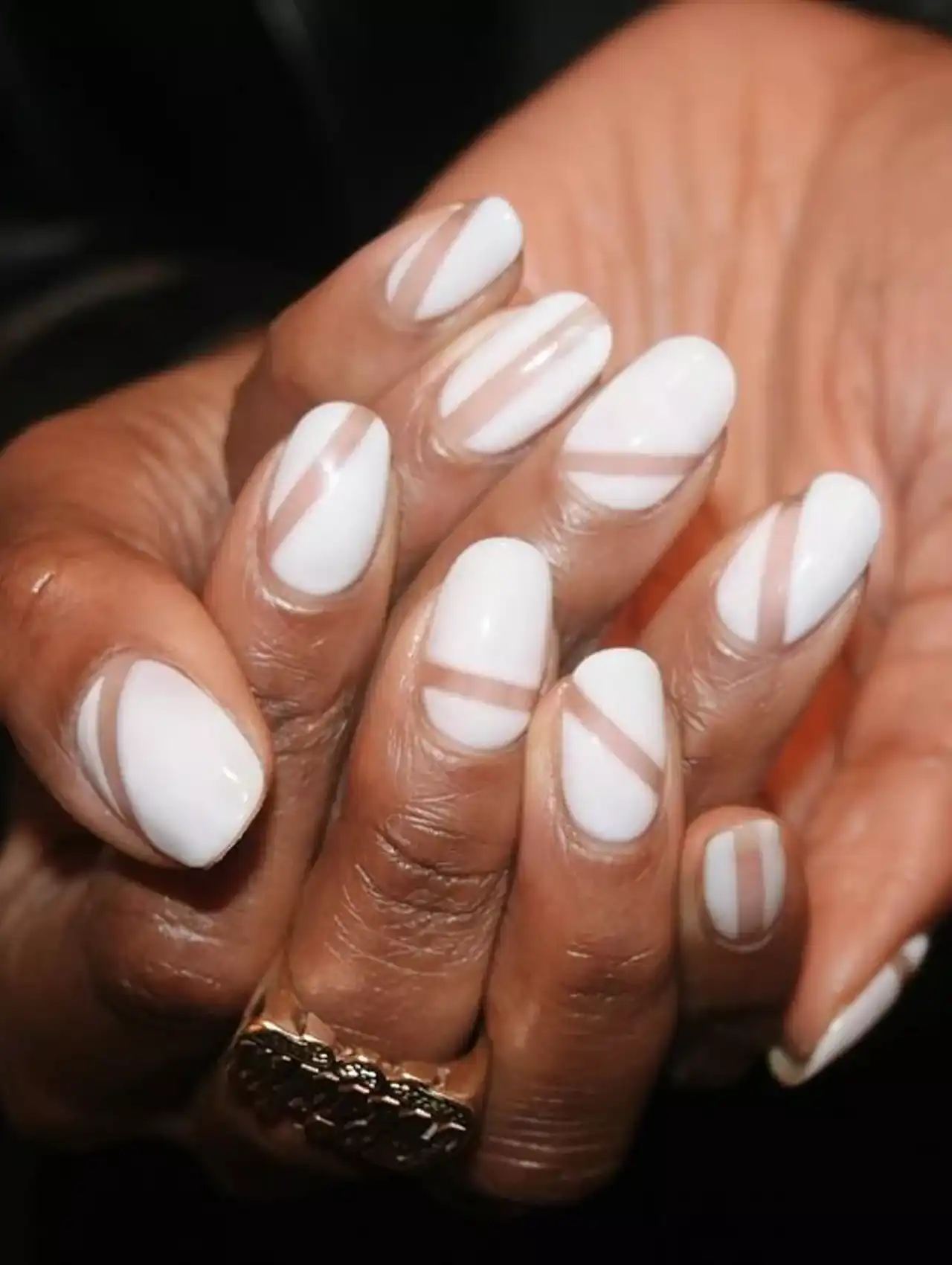 White nail polish with diagonal negative space stripes on natural nails.