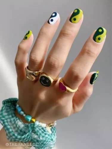 Trendy yin yang pop art nail design with vivid yellow and bold black accents