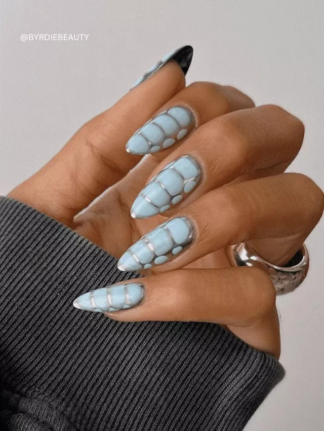 Icy blue croc-textured nails with blooming patterns.