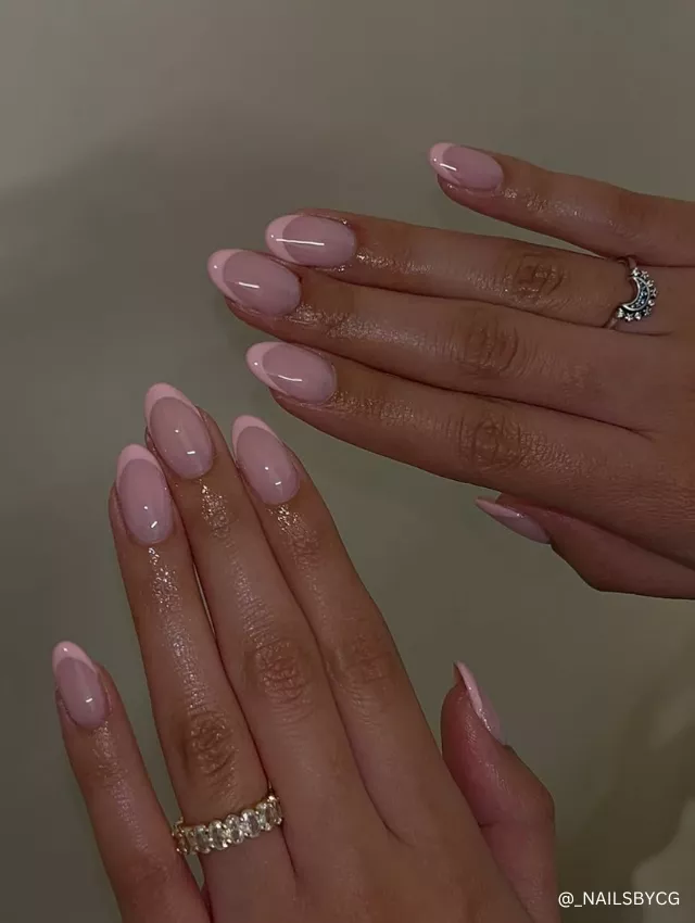 Elegant soft pink French manicure with a glossy almond-shaped finish for a timeless and chic look.