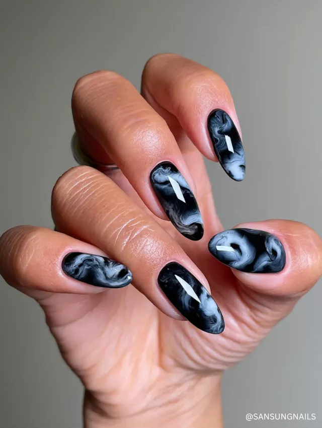 A mesmerizing black and white smoke marble nail design with a glossy finish.