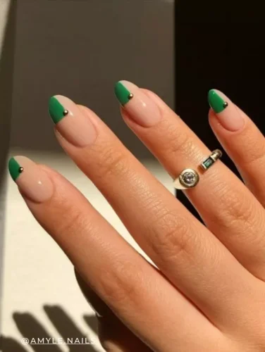 Elegant French tip nail design with a bold emerald green accent