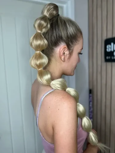 Elevate your hairstyle with this charming and playful bubble ponytail, perfect for adding a whimsical touch to any outfit. This unique style features a series of perfectly rounded 'bubbles' that are spaced evenly along the length of the ponytail, creating a fun and eye-catching look. The top is styled into a neat bun, adding a touch of elegance and making it suitable for both everyday wear and special occasions. This hairstyle is a fantastic choice for those looking to combine creativity with a flair for the dramatic. 🎈✨