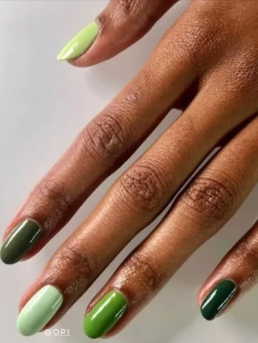 Contemporary nail design featuring a gradient of green shades on almond-shaped nails