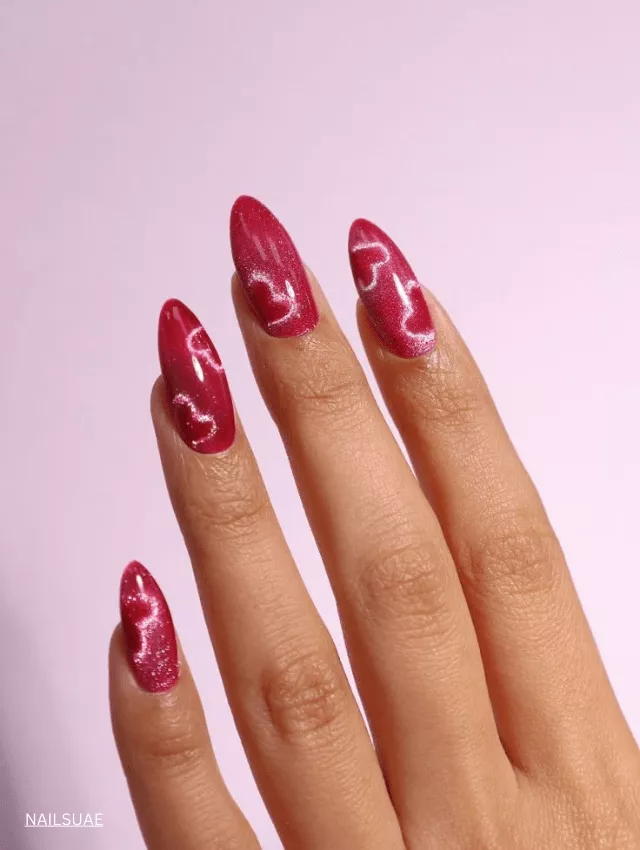 Vibrant hot pink velvet nails with delicate heart designs