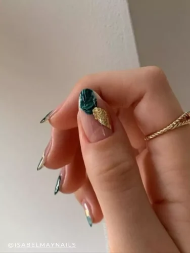 Luxurious nail art with deep green marbling and gold leaf accents on stiletto nails