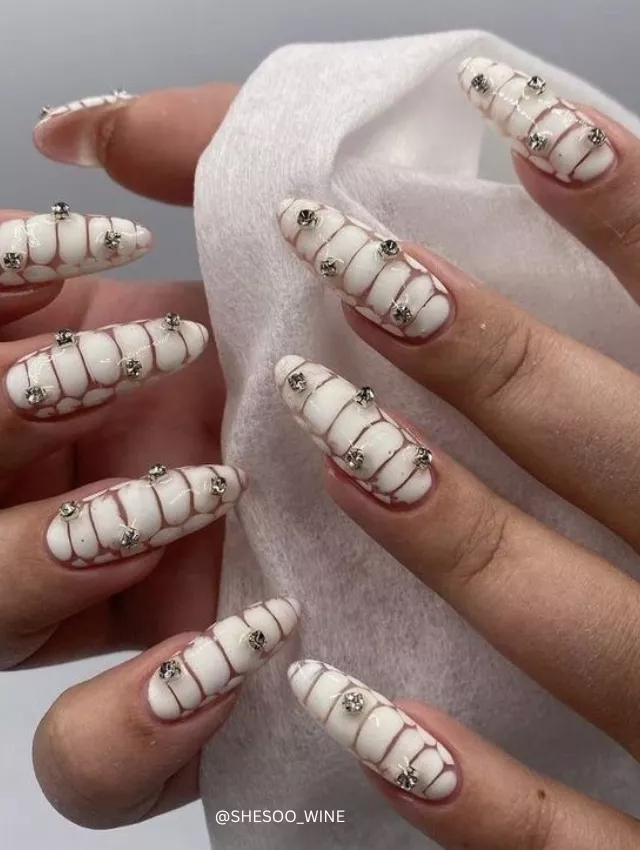 White blooming nails with crystal embellishments.