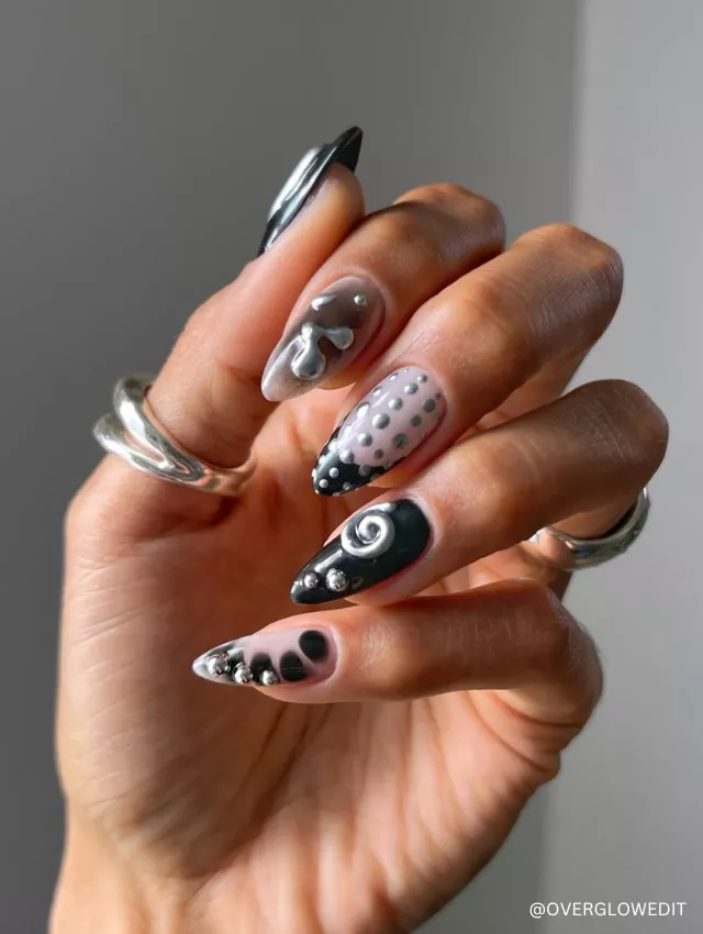 A bold black and silver 3D gothic nail design featuring intricate textures, metallic accents, and abstract patterns.
