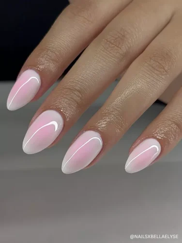 Elegant pink and white gradient almond nails with a subtle glossy finish and minimalist white swirl details.