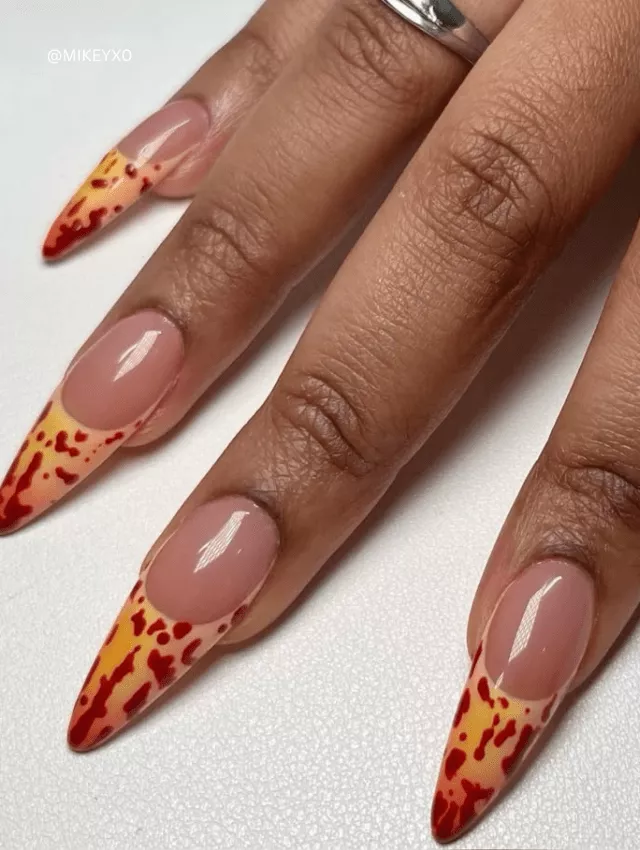 Nude stiletto nails with fiery red and yellow blooming tips.