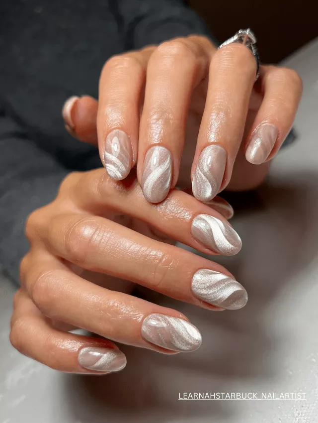 Frosty white velvet nails with abstract, shimmering swirl designs.