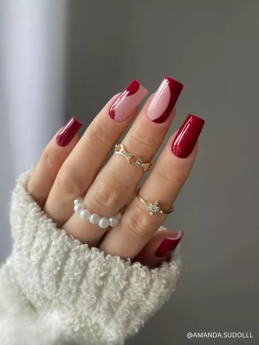 A stylish square-shaped manicure featuring deep red polish with a modern twist on classic French tips.