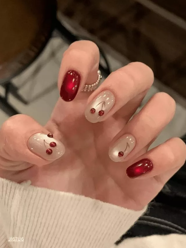 Rich cherry red velvet nails with a glowing cat-eye effect.