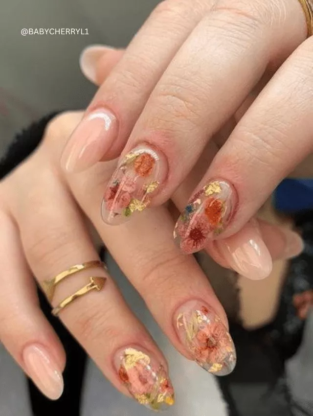 Nude almond nails with real dried flowers and gold flakes.