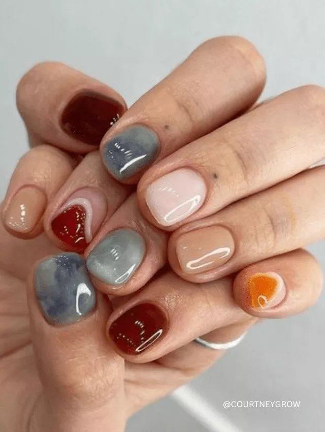 Short nails with abstract earthy tones and glossy finish.