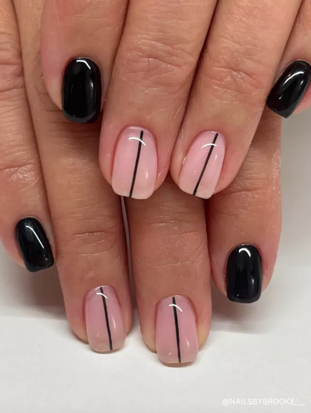 A modern minimalist nail design featuring glossy black nails and nude nails with sleek black line accents.