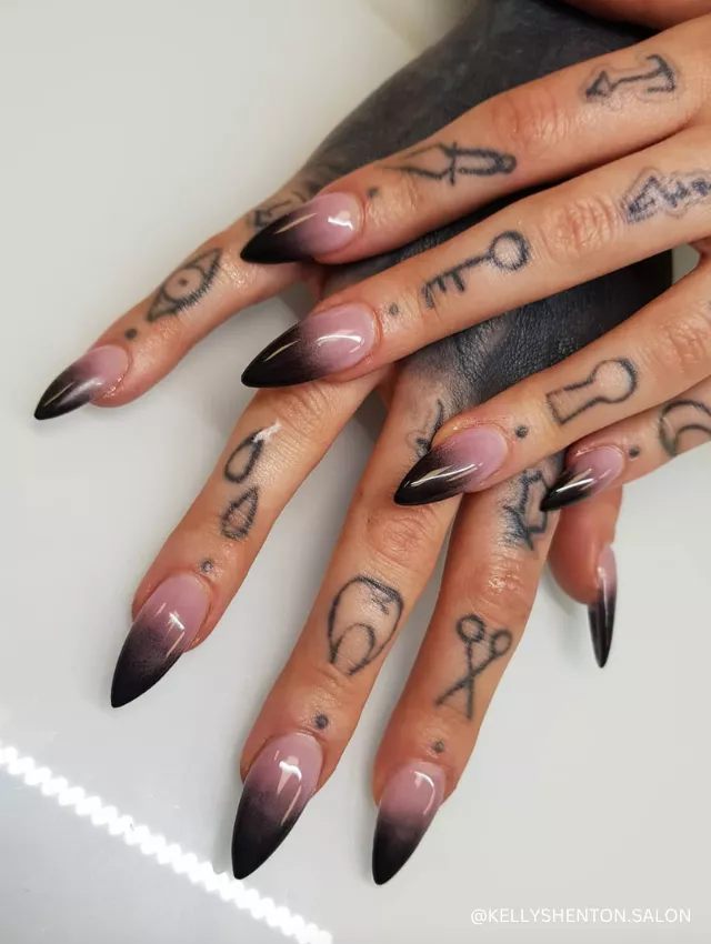 A striking black ombre nail design with a smoky gradient effect on long stiletto nails.