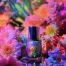 A holographic nail polish bottle surrounded by a vibrant floral arrangement.