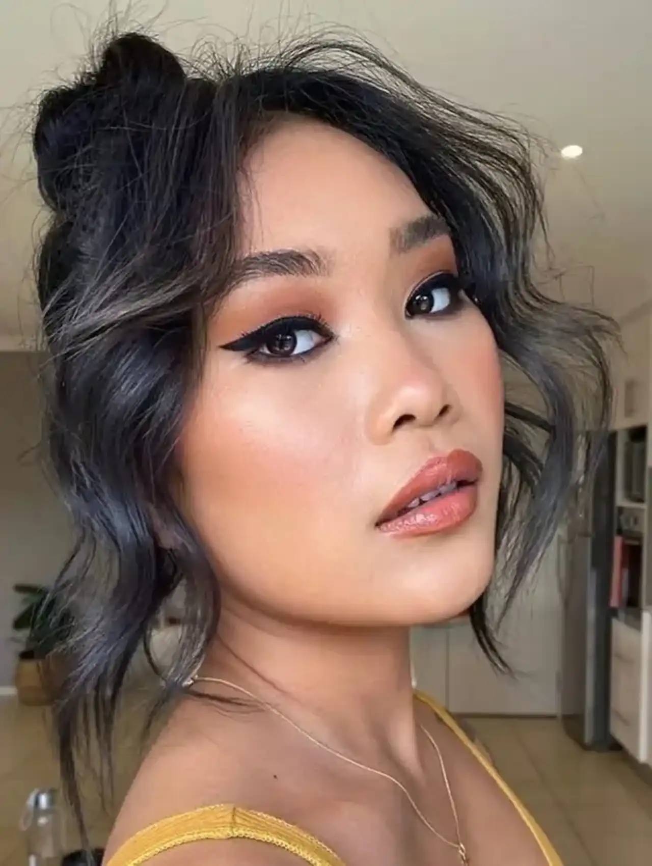 Modern messy bun with loose strands - easy hairstyles for chic style