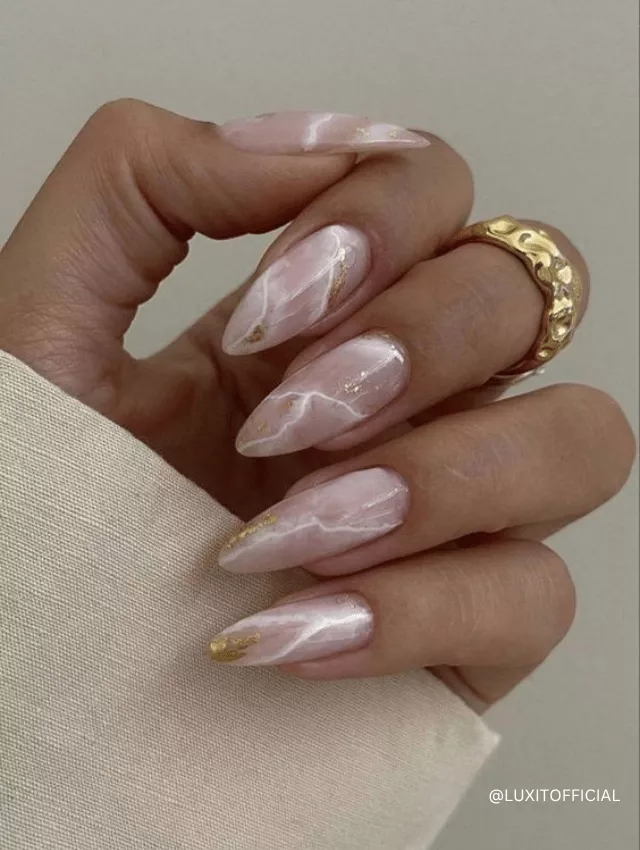 Delicate pink marble nails with white and gold veining.