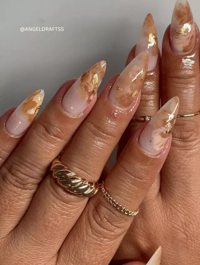 Nude and white marble nails with gold foil details.